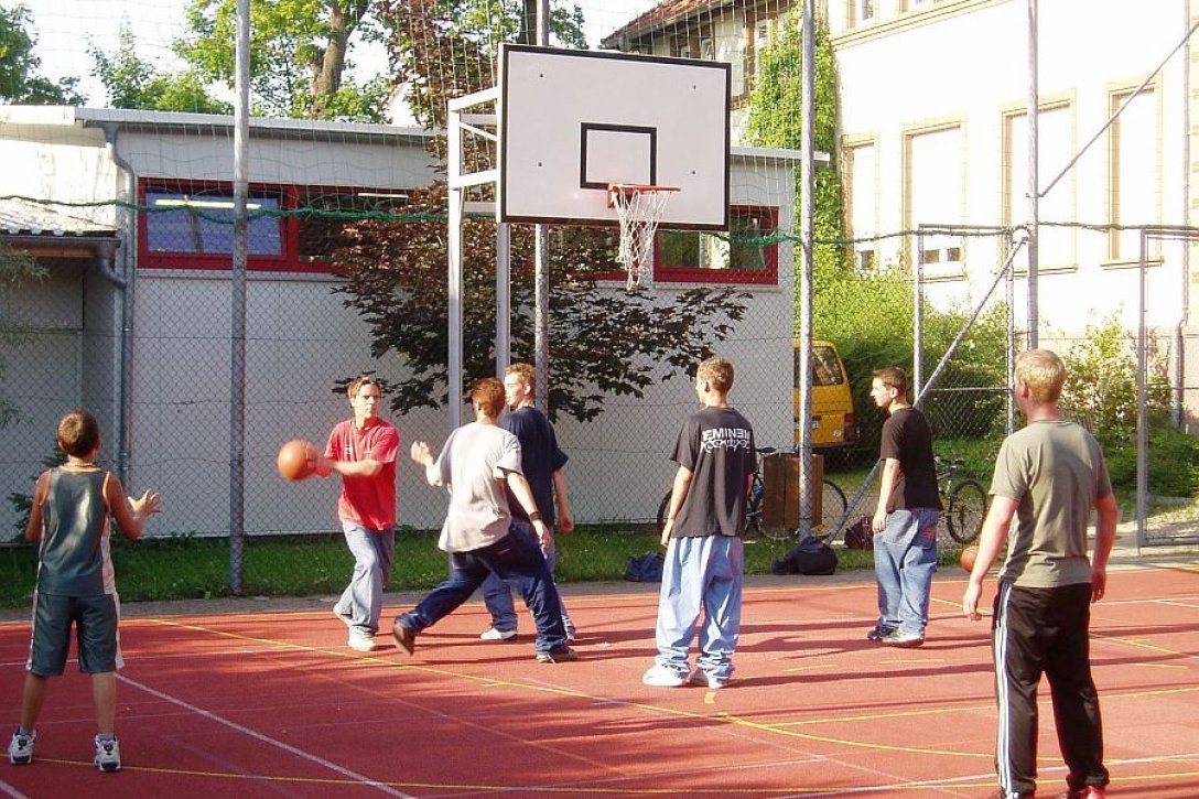 Jugendliche spielen Basketball auf dem Sportplatz der Villa Lampe in Heiligenstadt 