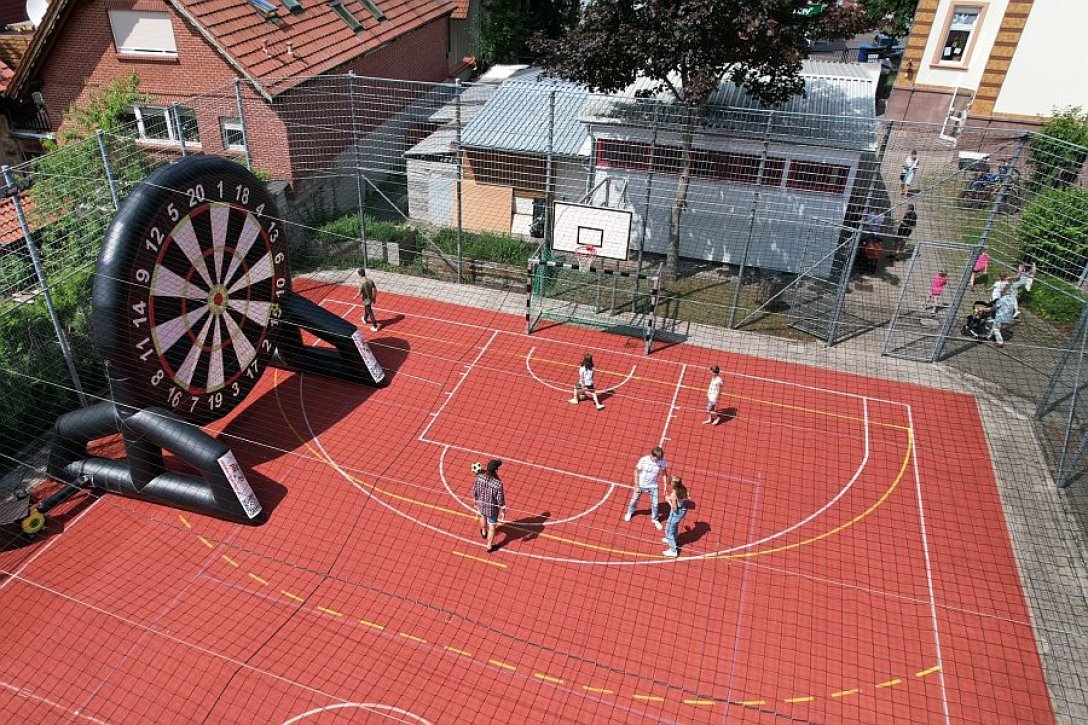 Blick von oben auf den Sportplatz der Villa Lampe von Don Bosco in Heiligenstadt. Links eine aufblasbare Fußball-Dartscheibe. 