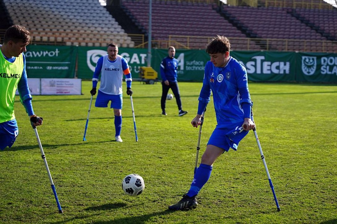 Männer mit amputierten Beinen spielen mit Krücken Fußball 